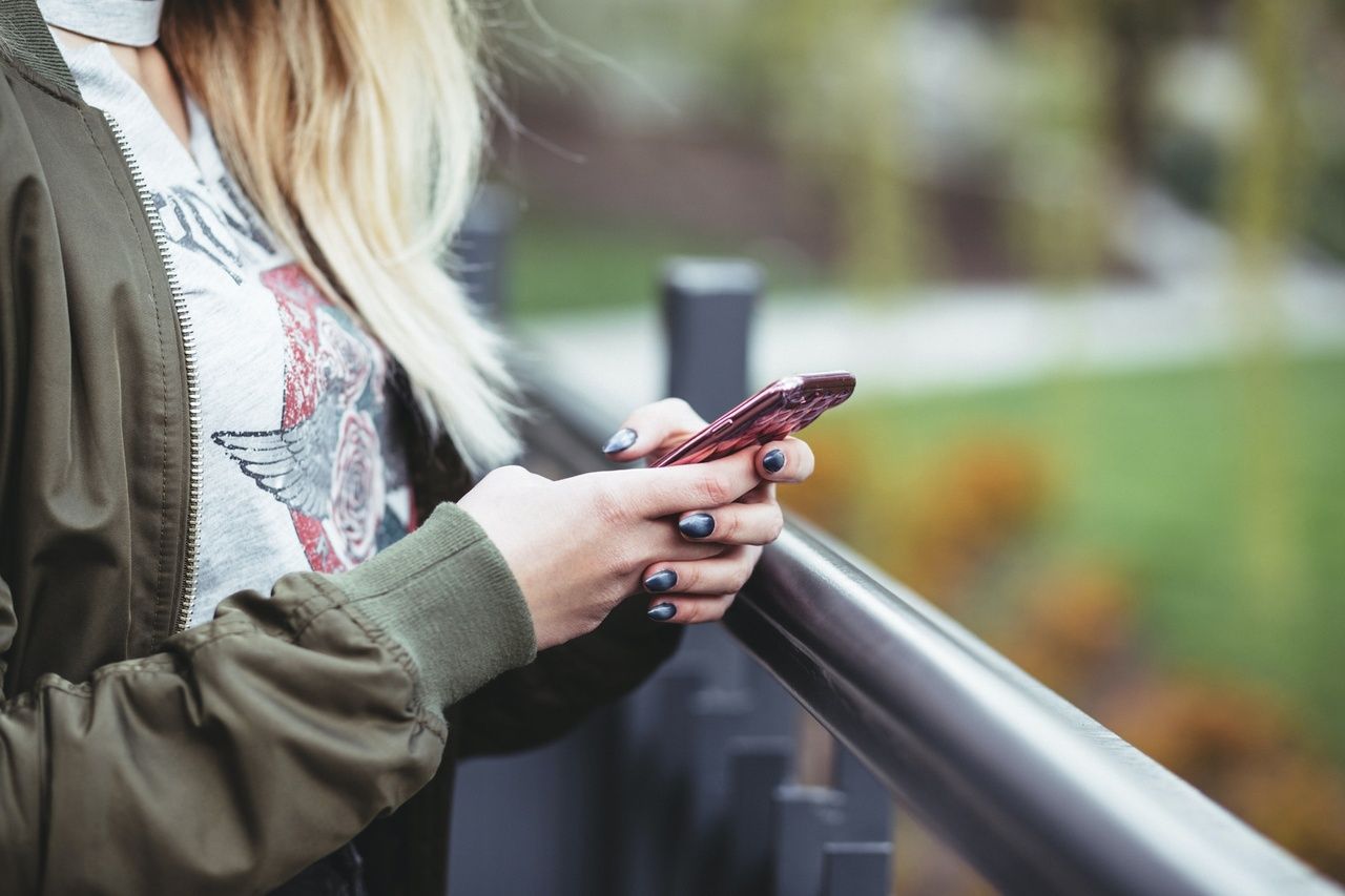 a woman holding a red mobile phone