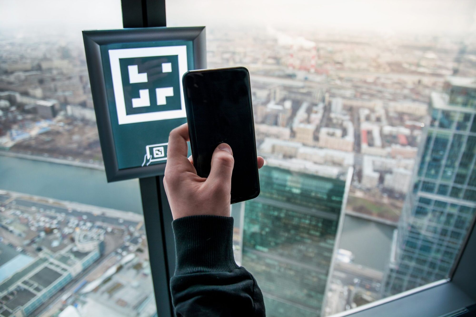 a person scanning a QR code in a building with a view