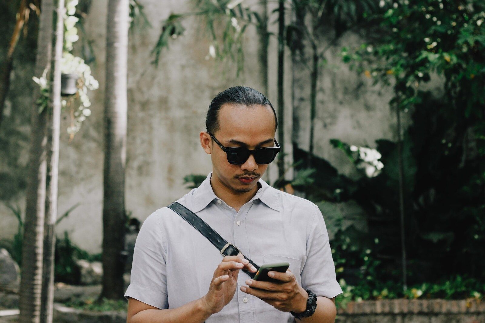 a man in white shirt holding a phone