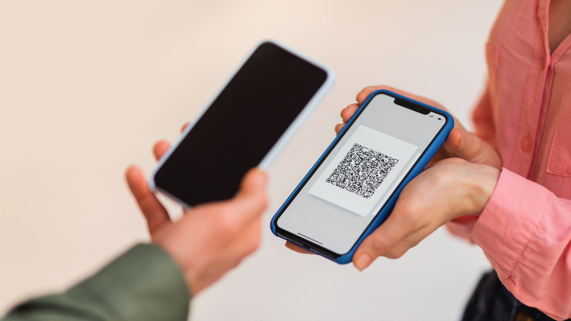 a hand scanning a QR code from another phone