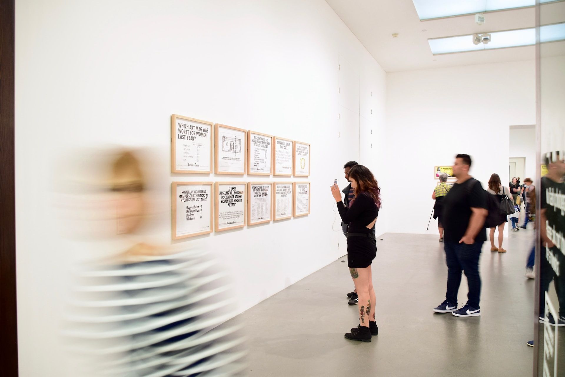 people looking at frames with texts at an art museum