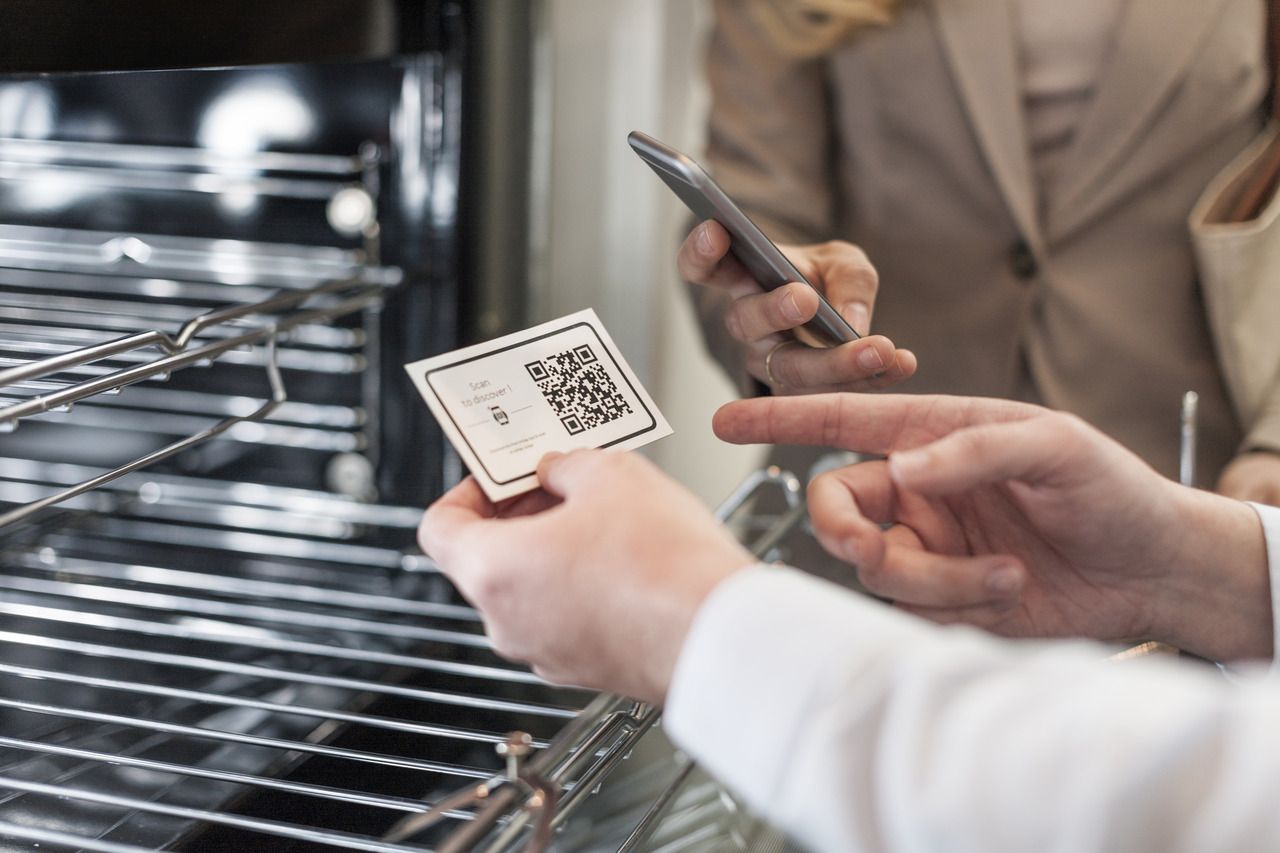 shop assistant showing a business card with a QR code