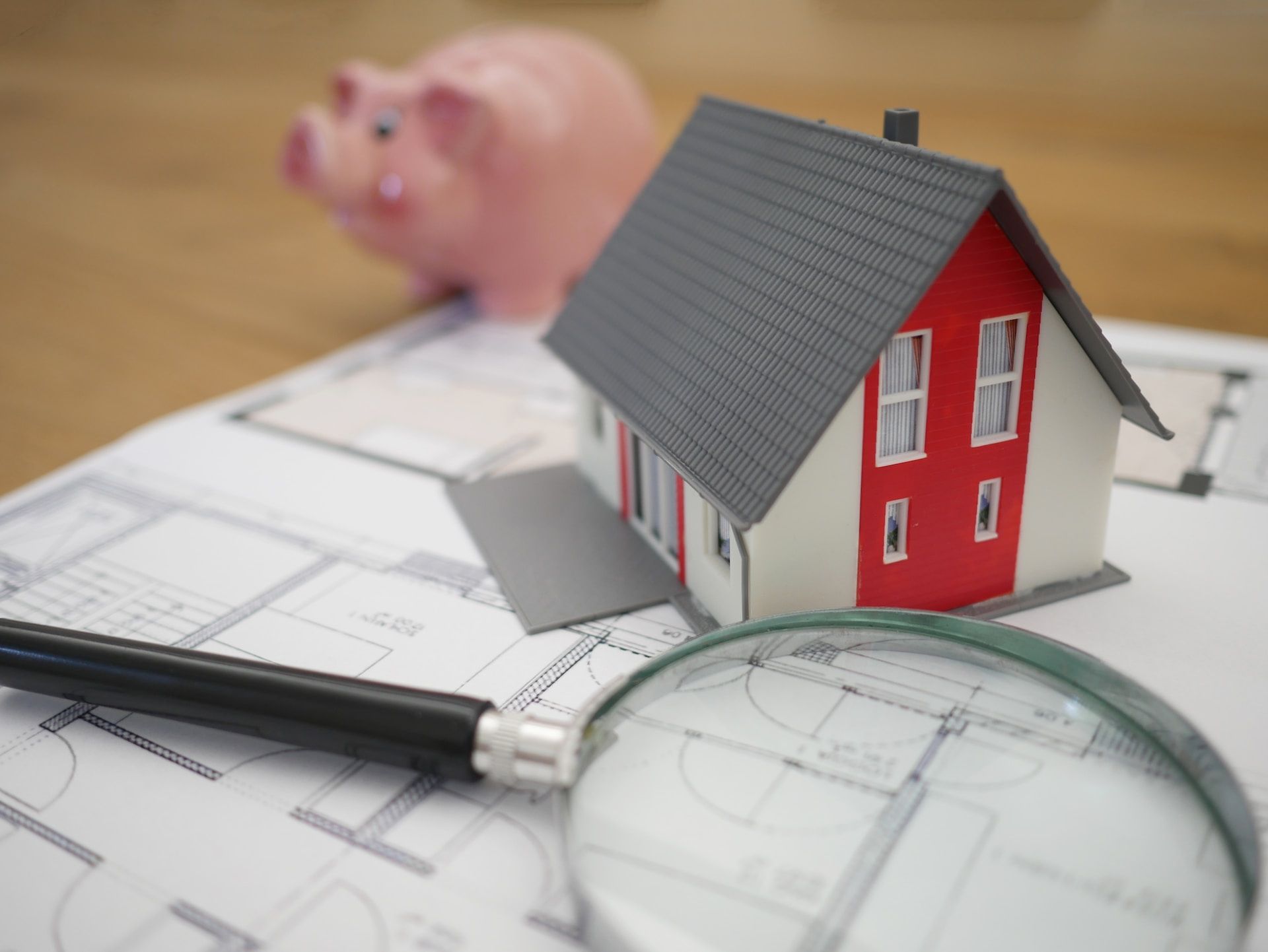 white and red wooden house beside magnifying glass