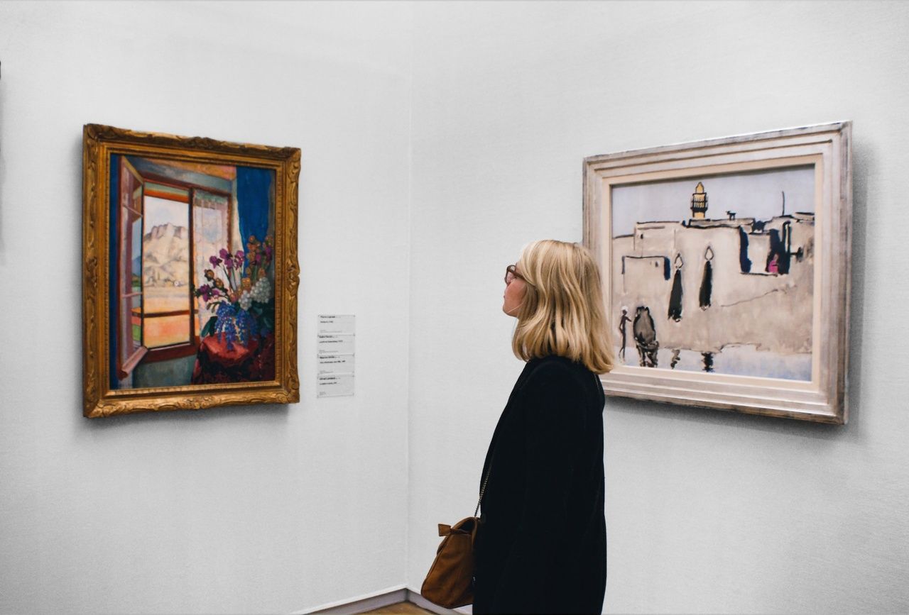 a woman looking at a painting at a museum