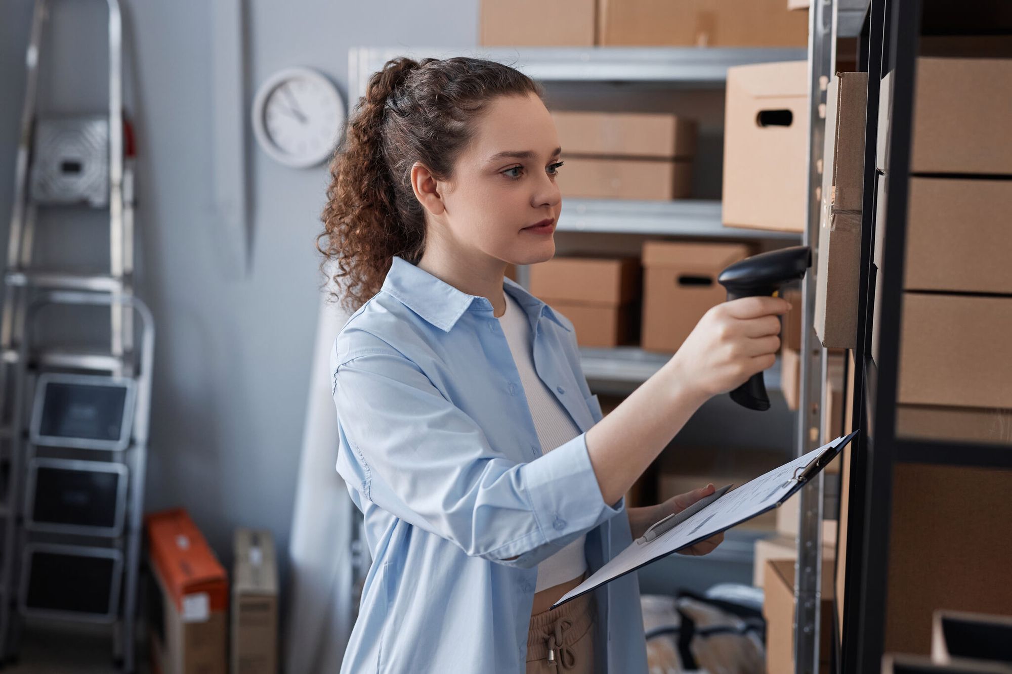 a woman scanning QR codes on packages for inventory management