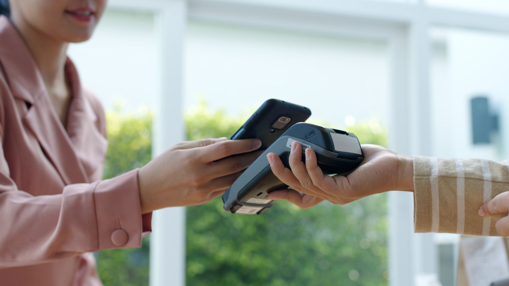 close-up of a woman scanning a QR code for payment