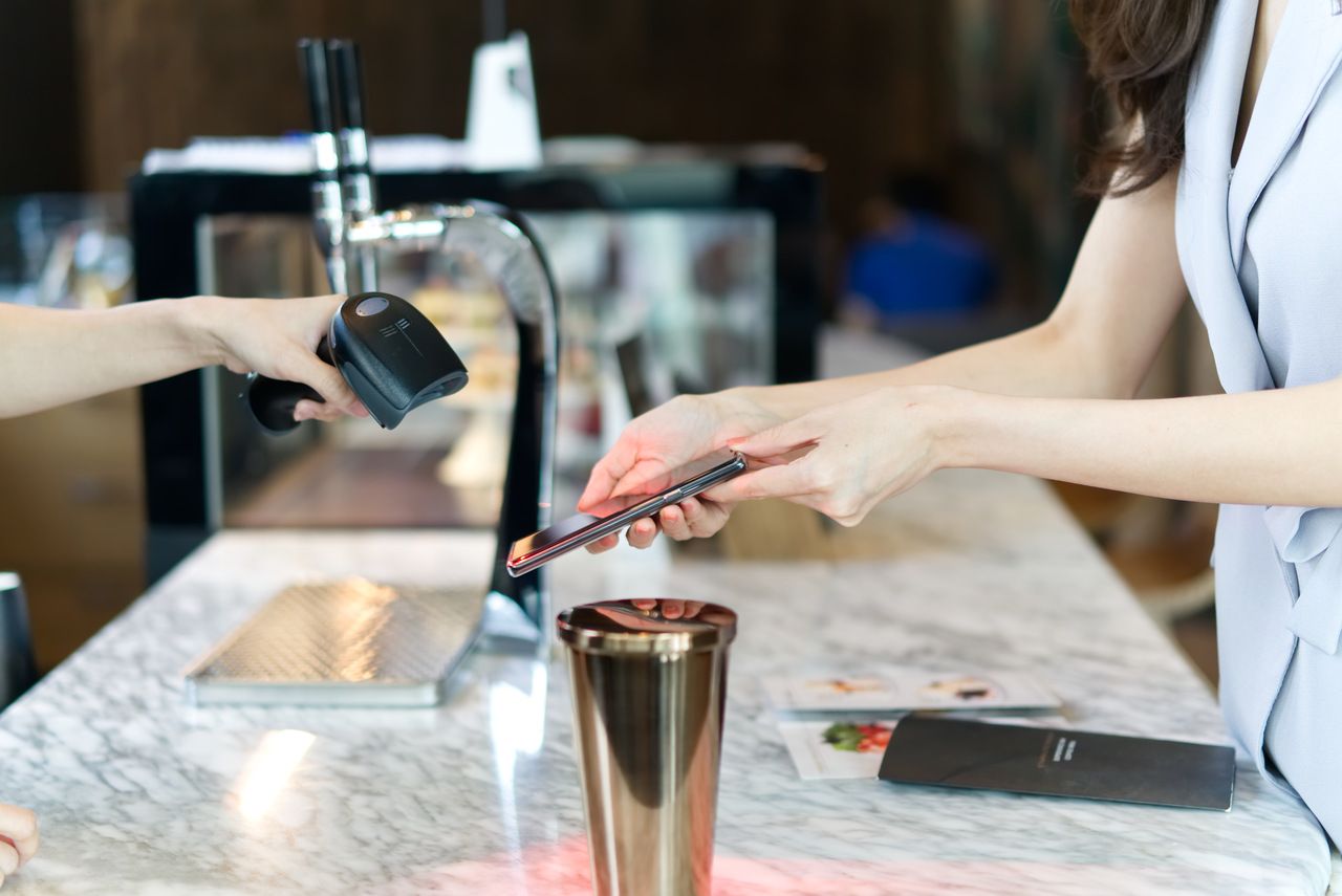 close up of a woman customer hand using a smartphone to scan a QR code