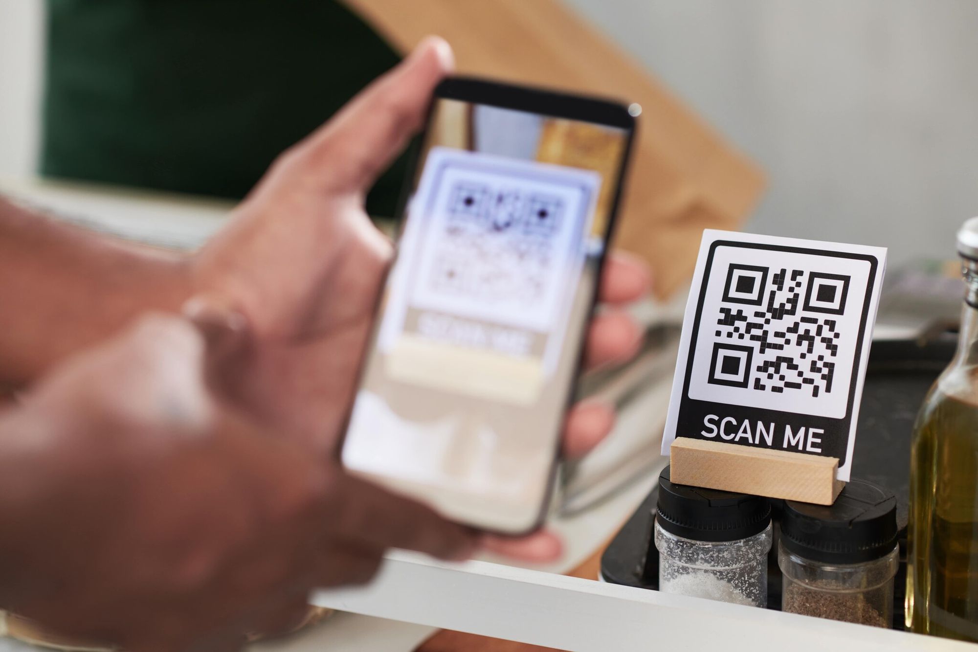 a hand scanning a QR code on the counter that says "Scan me"