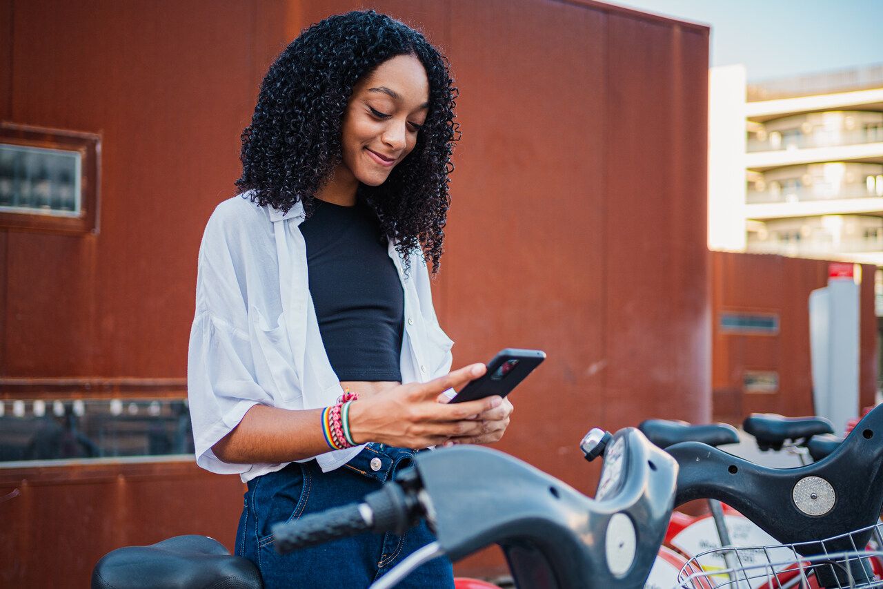 girl scanning a QR code on a bicycle and smiling