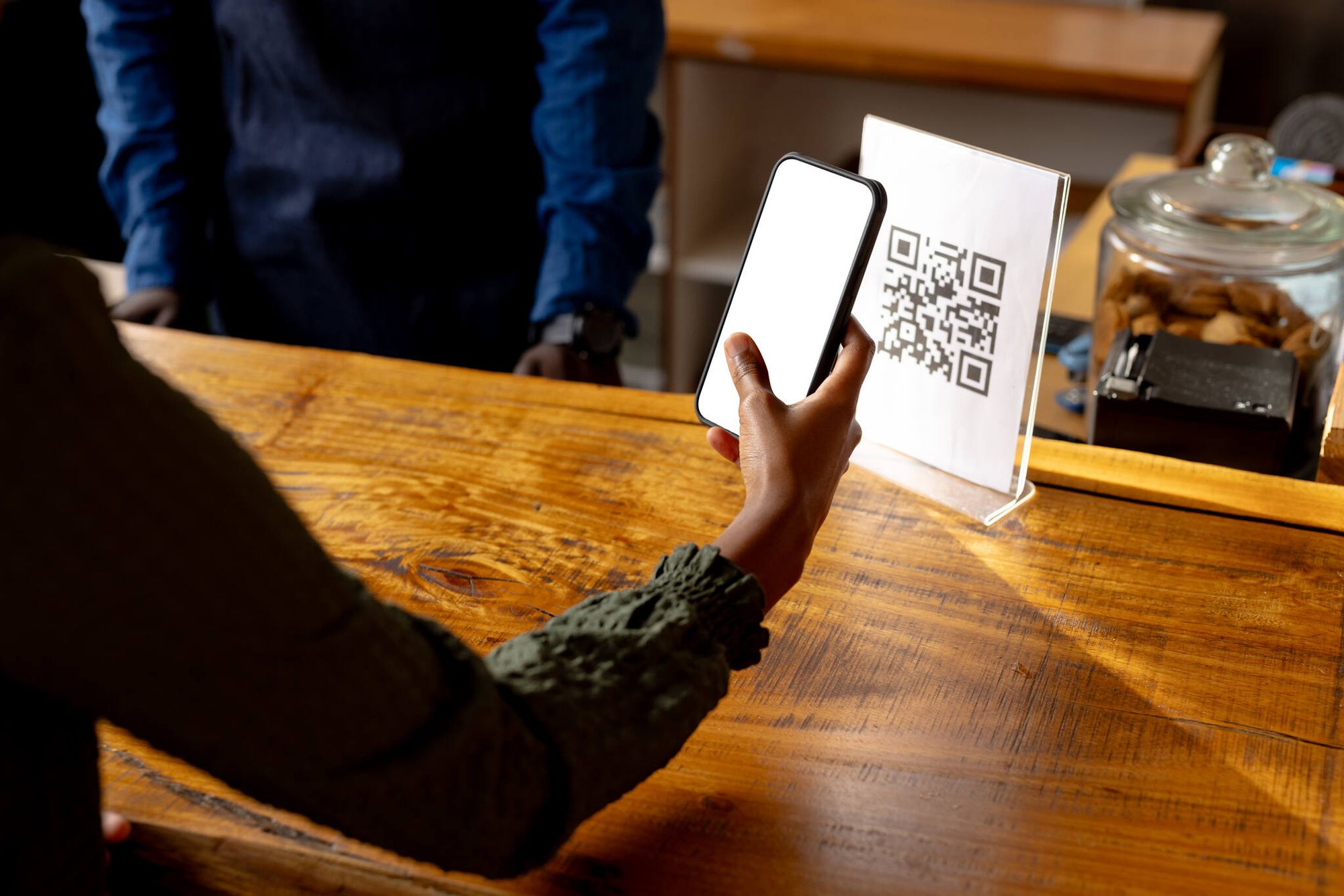 hand of a woman scanning a QR code on the counter