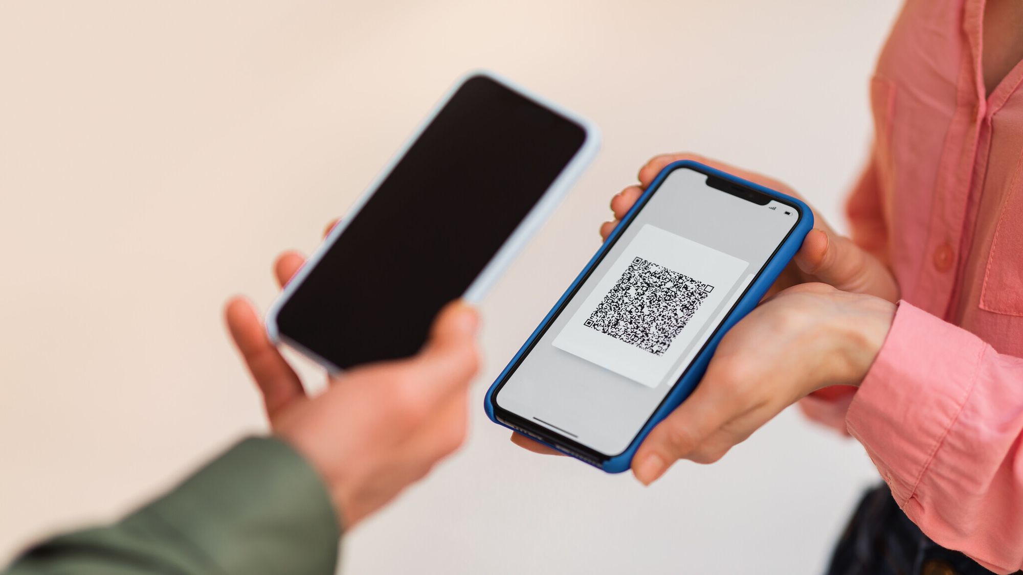 a man using phone & scanning a QR code on another phone