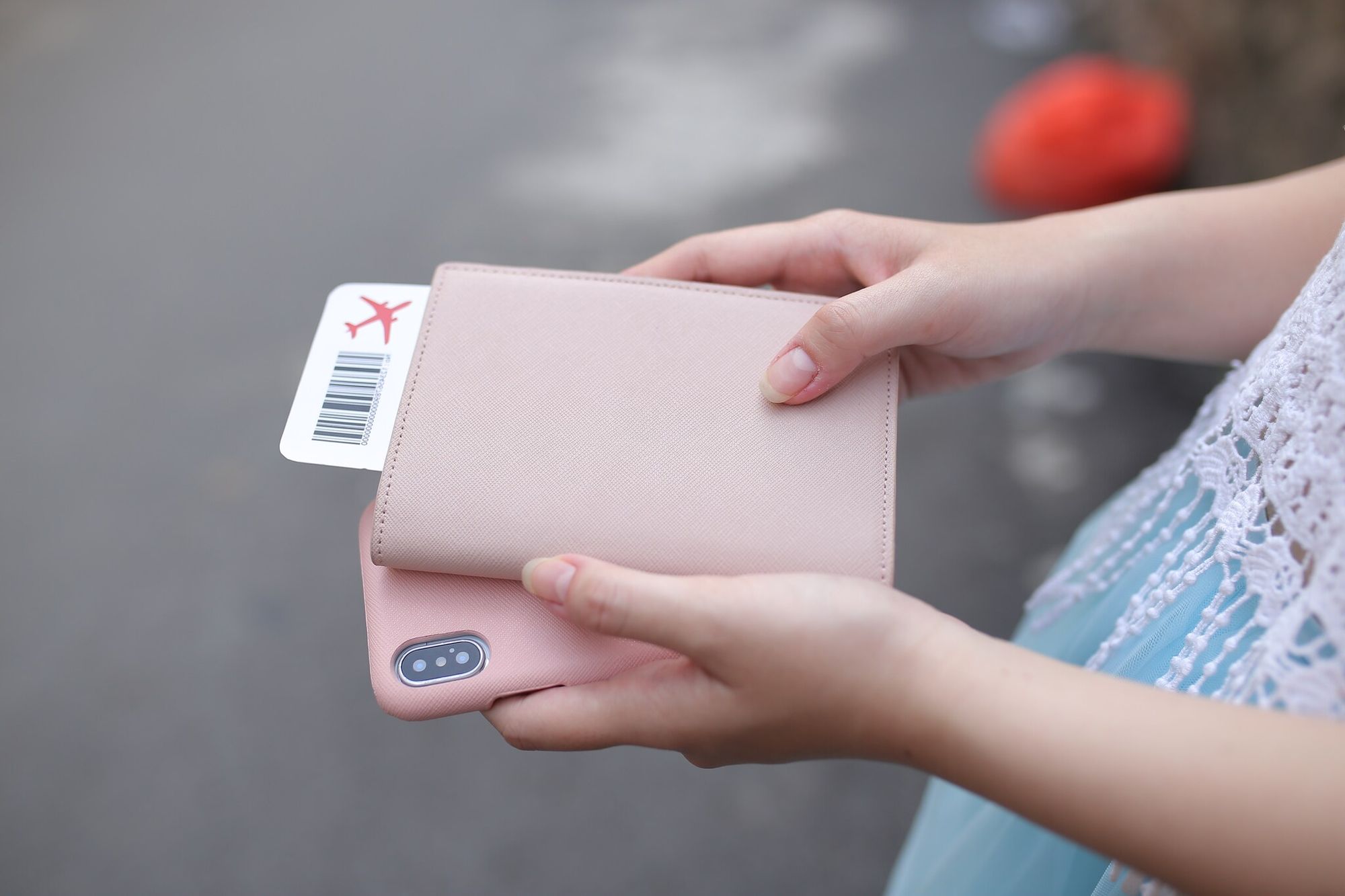 person holding pink smartphone and wallet