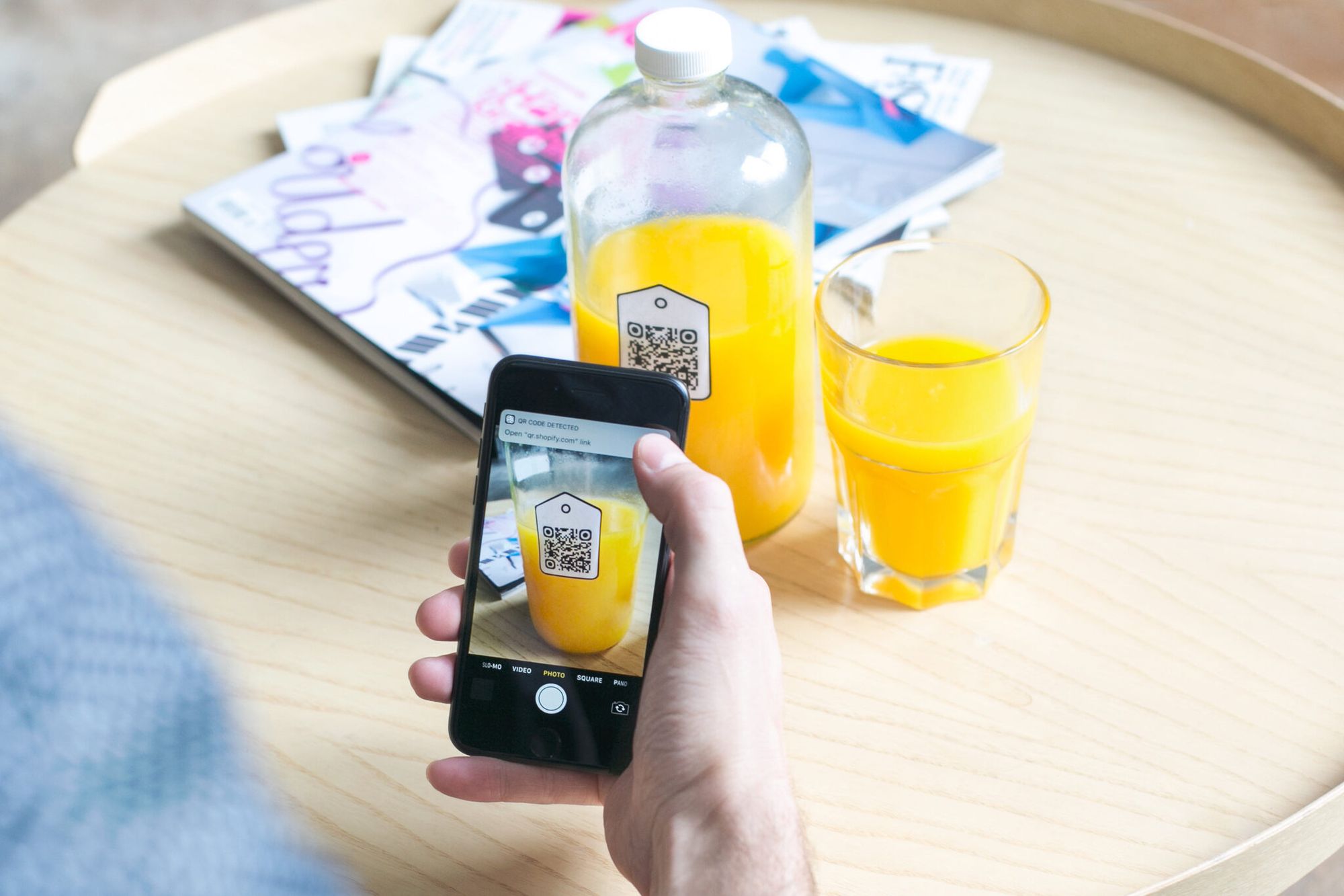 a hand scanning a QR code on a juice bottle