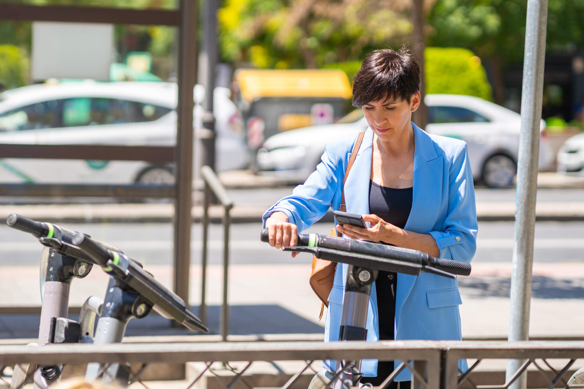 Serious woman scanning QR code on an electric scooter