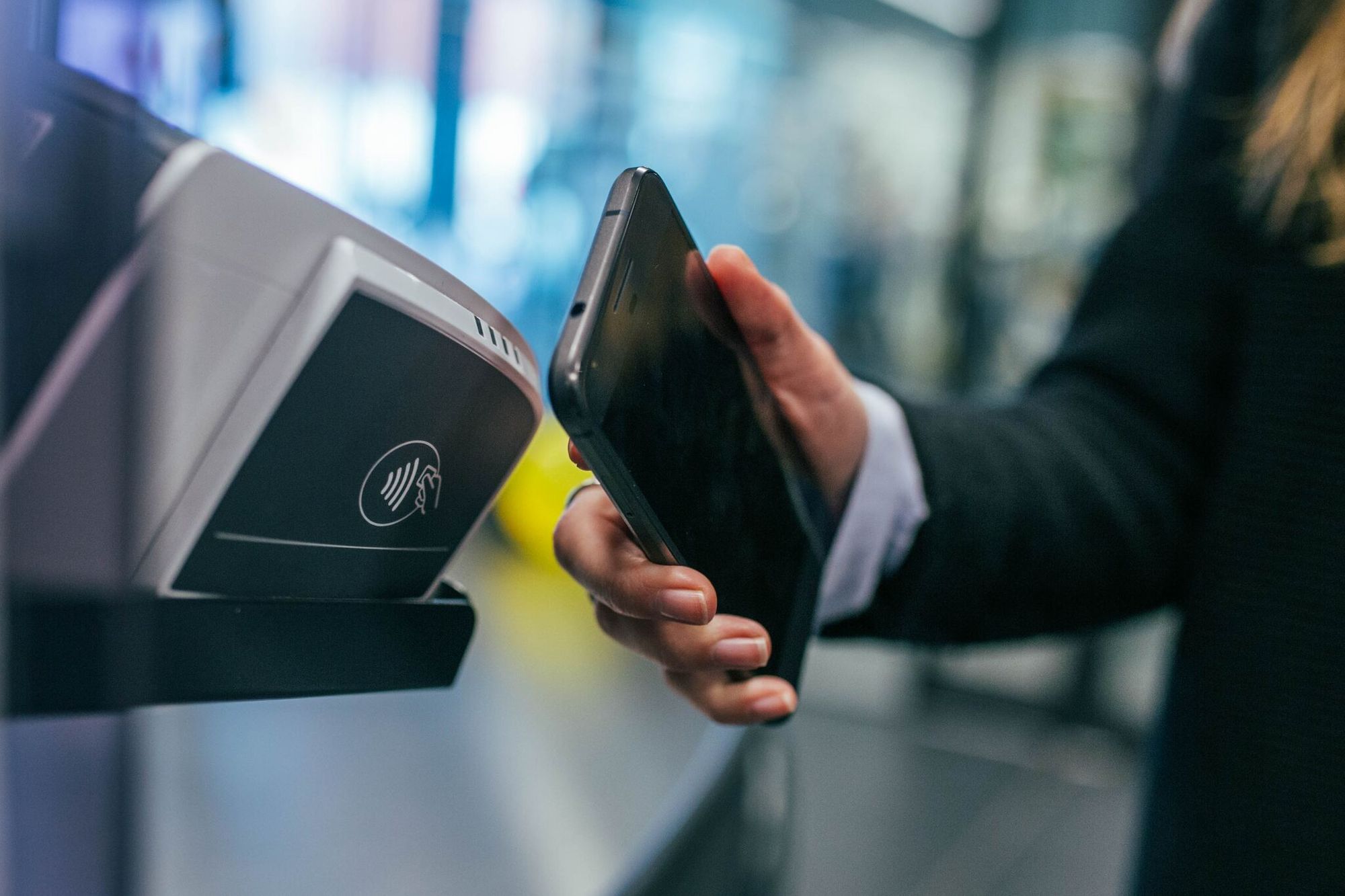 Woman holding a phone and scanning NFC for payment