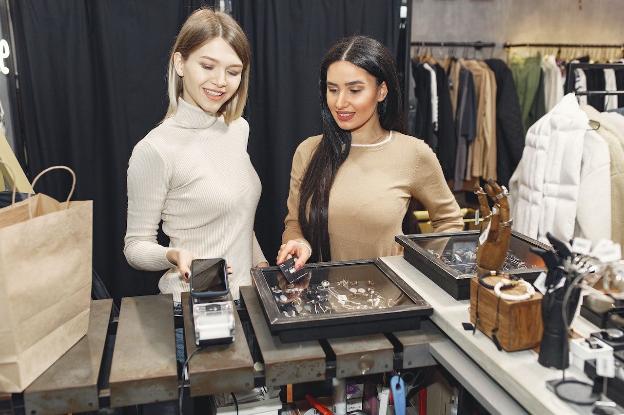 women paying for clothes with smartphone