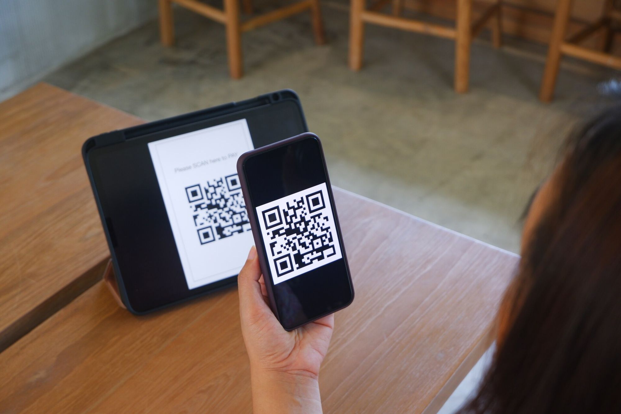 a qoman scanning QR code for payment