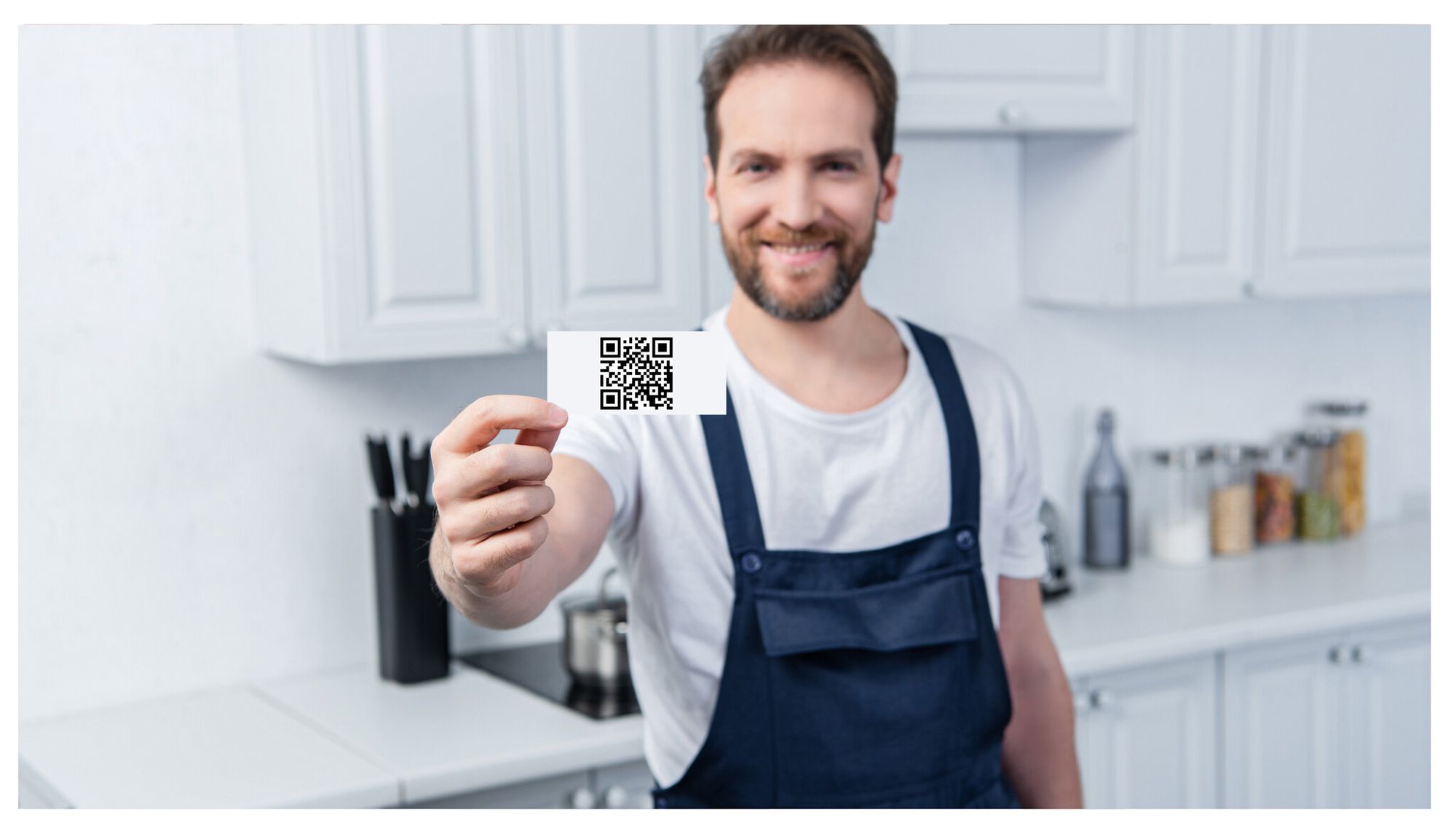 A man showing a card with a QR code and smiling