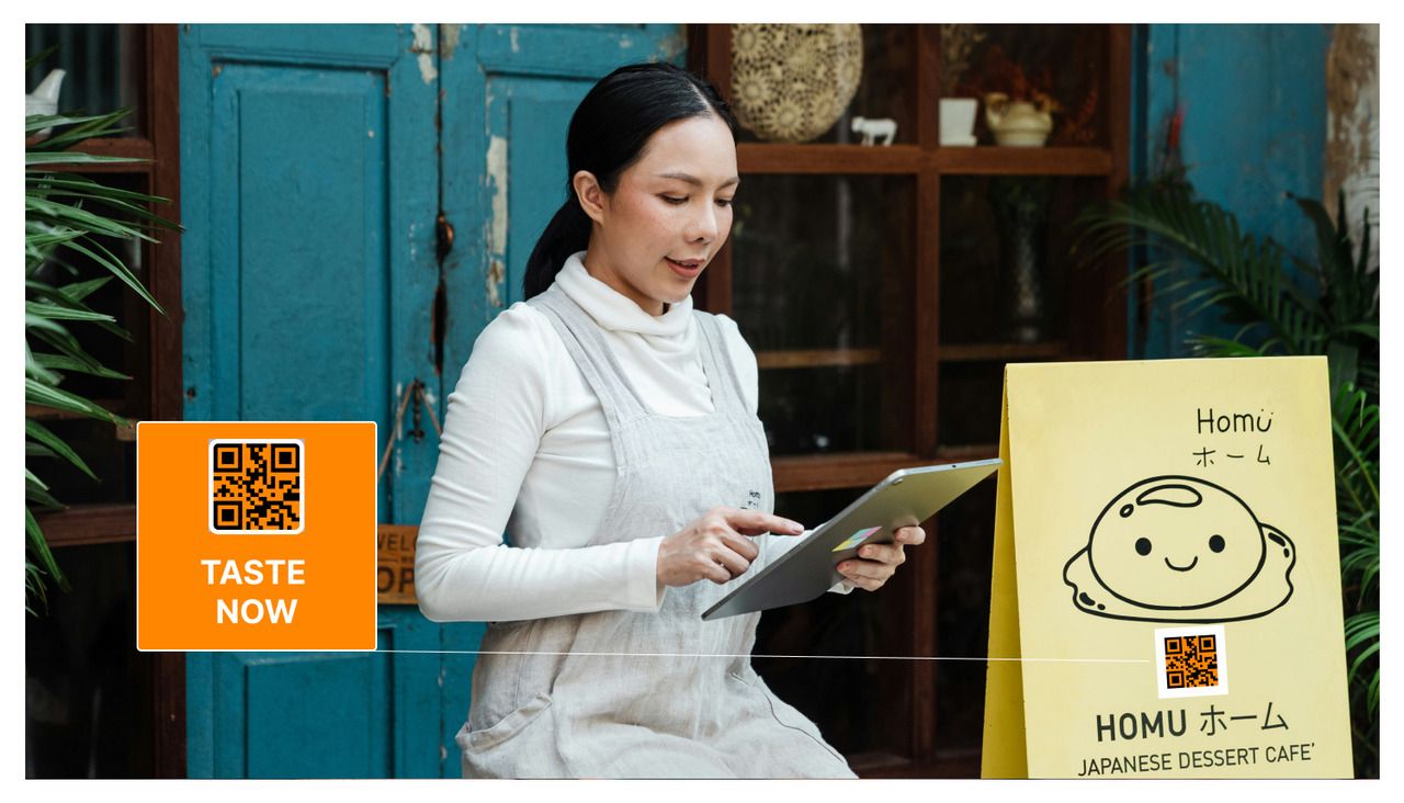 A woman checking at a tablet and a menu with a QR code next to her