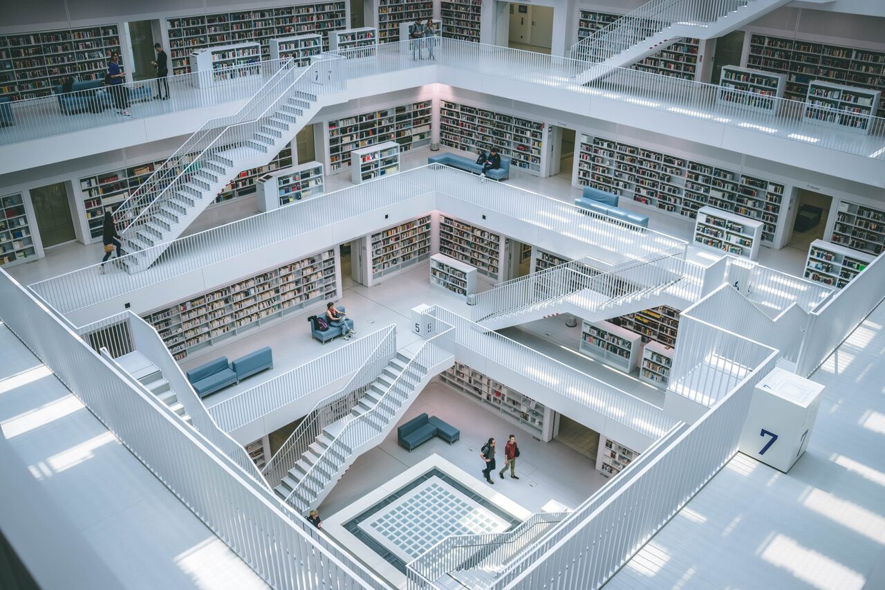 people walking in a big library