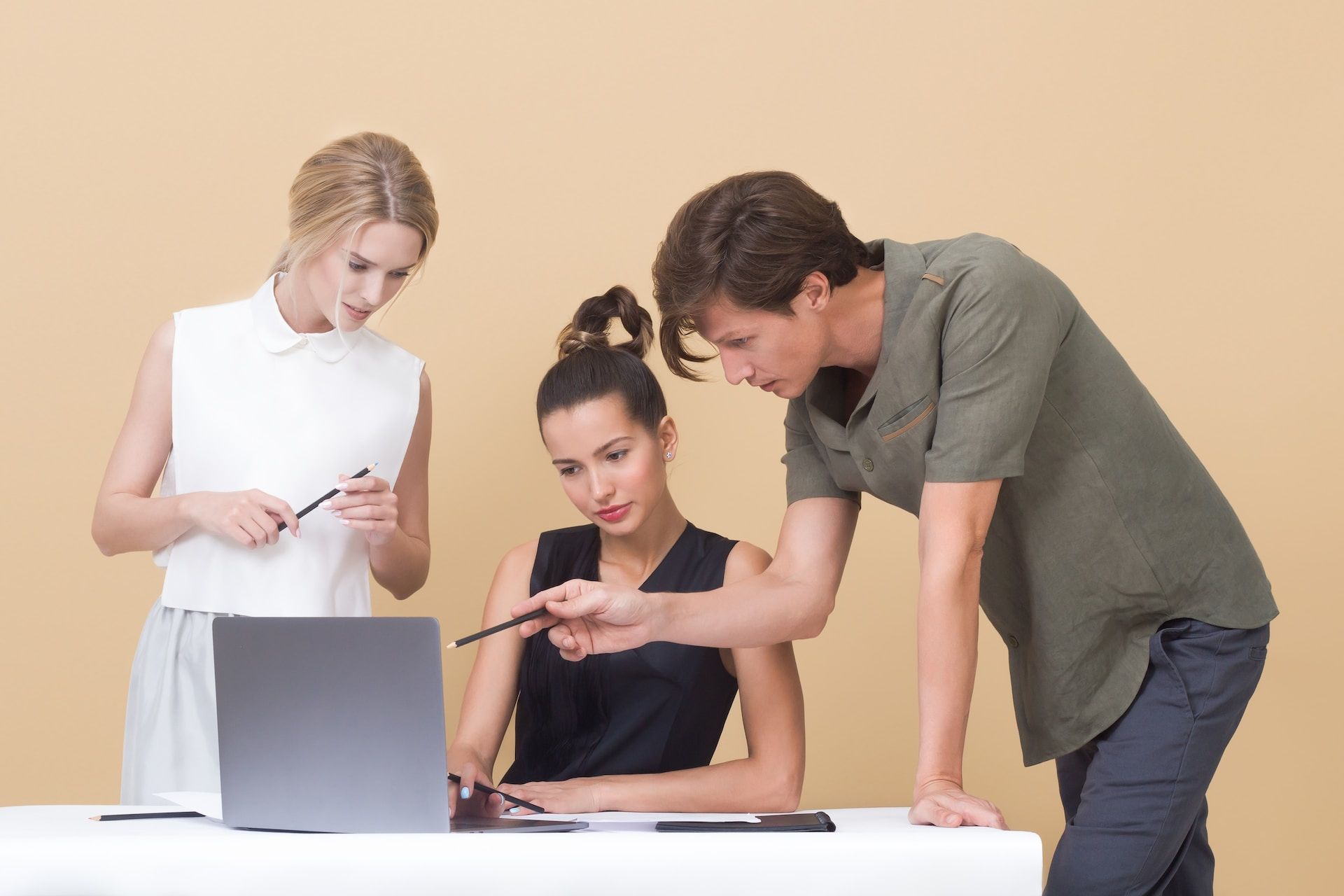 three people looking at a laptop screen