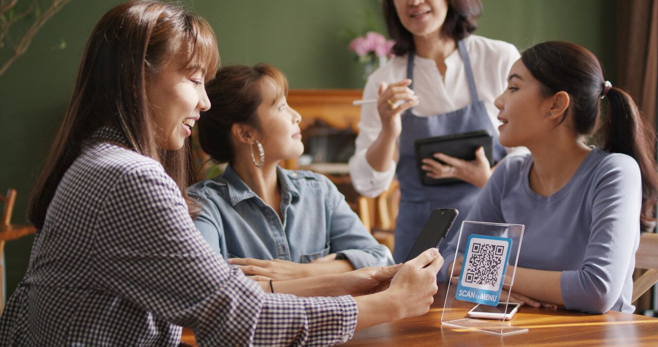 waiter and customers speaking on a table with QR code